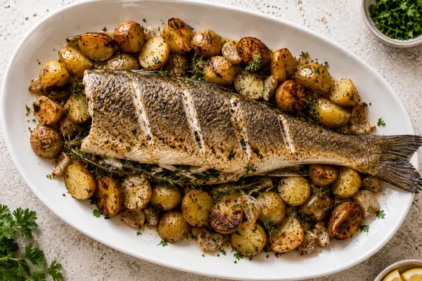 Oven roasted whole branzino with lemon slices and herbs